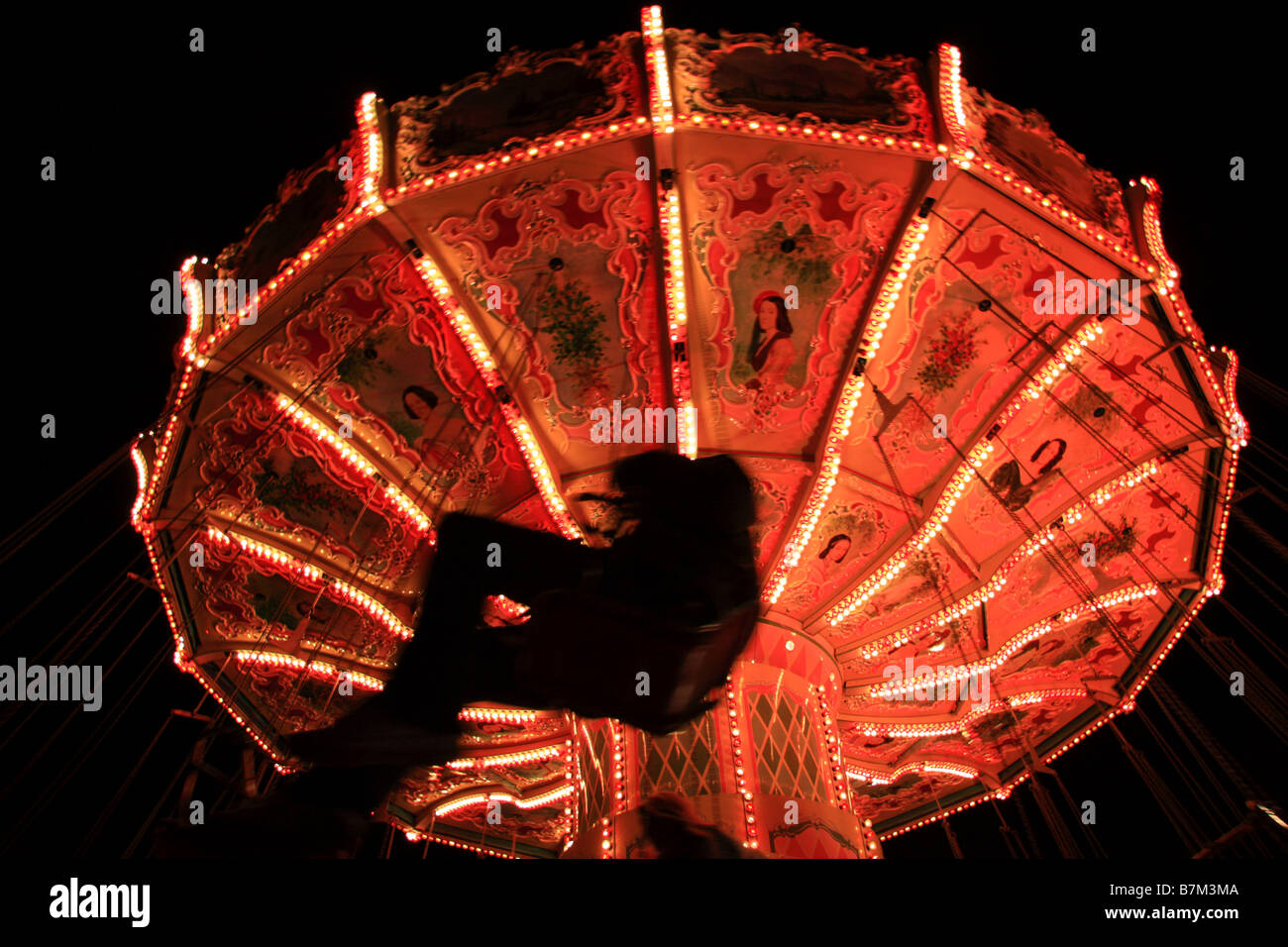 La silhouette du cavalier au carrousel traditionnel siège enchaînés ride au Winter Wonderland, Hyde Park, London Banque D'Images