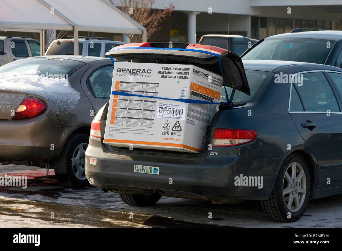 Générateur électrique de secours chargé dans le dos d'une voiture après une tempête de glace. Banque D'Images