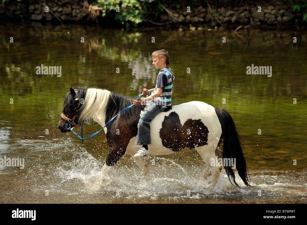 Un garçon rom rides bareback sur un cheval dans la rivière Eden à Appleby Appleby dans Westmoreland gypsy foire aux chevaux Banque D'Images