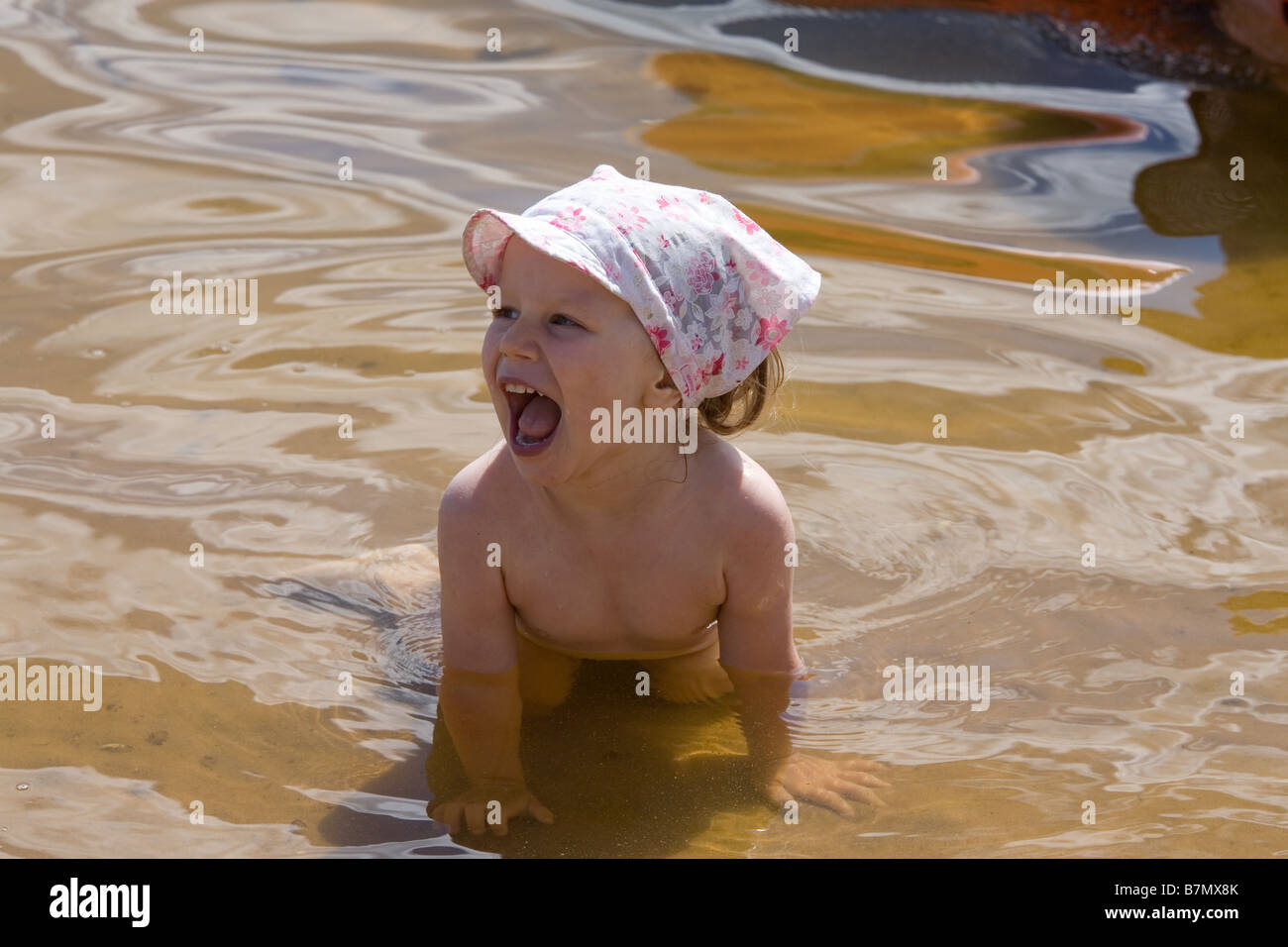 Deux ans, fille, jouant dans l'eau Banque D'Images