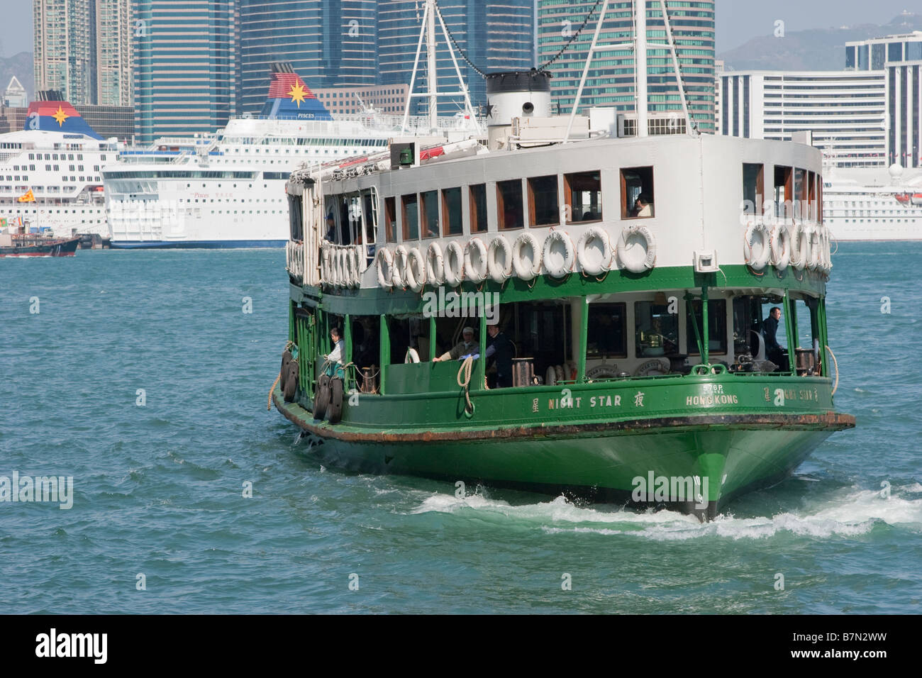 Le célèbre et traditionnel Star Ferry à double extrémité quitte Hong Kong Island en routeTsim Sha Tsui, Kowloon qui peut être vu dans le fond. Banque D'Images