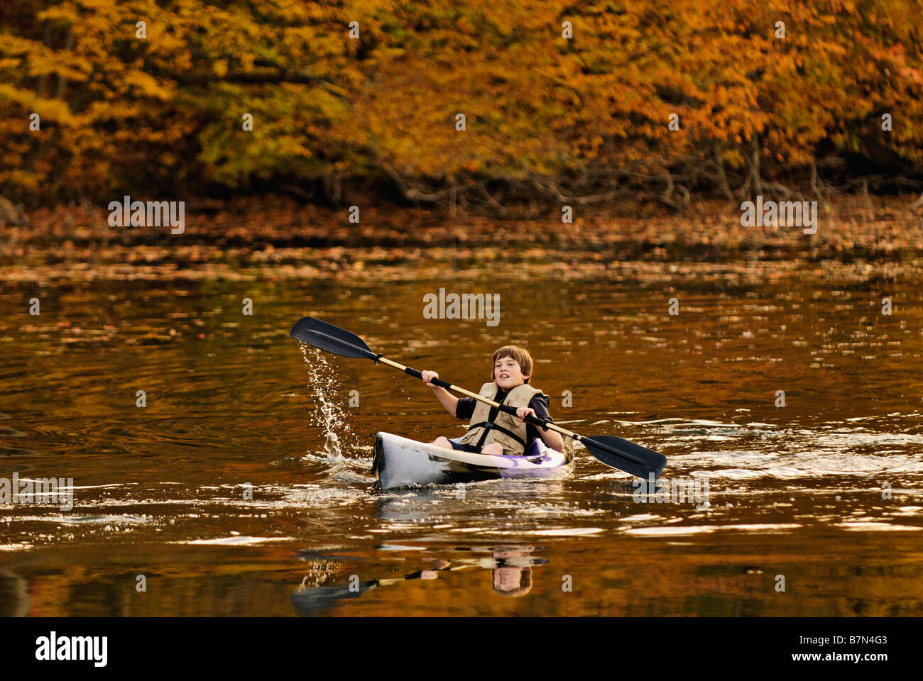 Boy Paddling kayak sur le lac de forêt en automne à la Mount Saint Francis dans Floyd County Indiana Banque D'Images