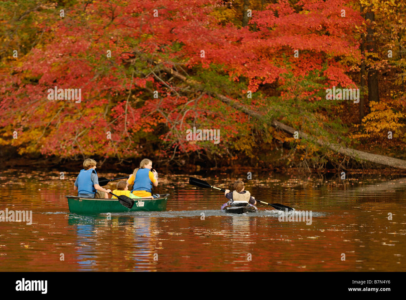 Les adolescents en canoë et kayak sur le lac de forêt en automne à la Mount Saint Francis dans Floyd County Indiana Banque D'Images