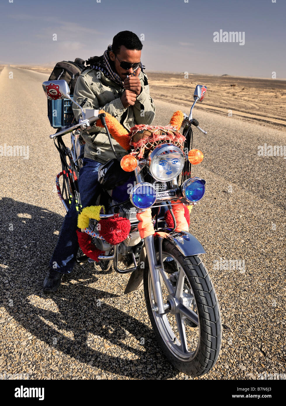 À la lumière d'arrêt motorbiker égyptien de cigarette en riad à désert occidental de l'égypte Banque D'Images