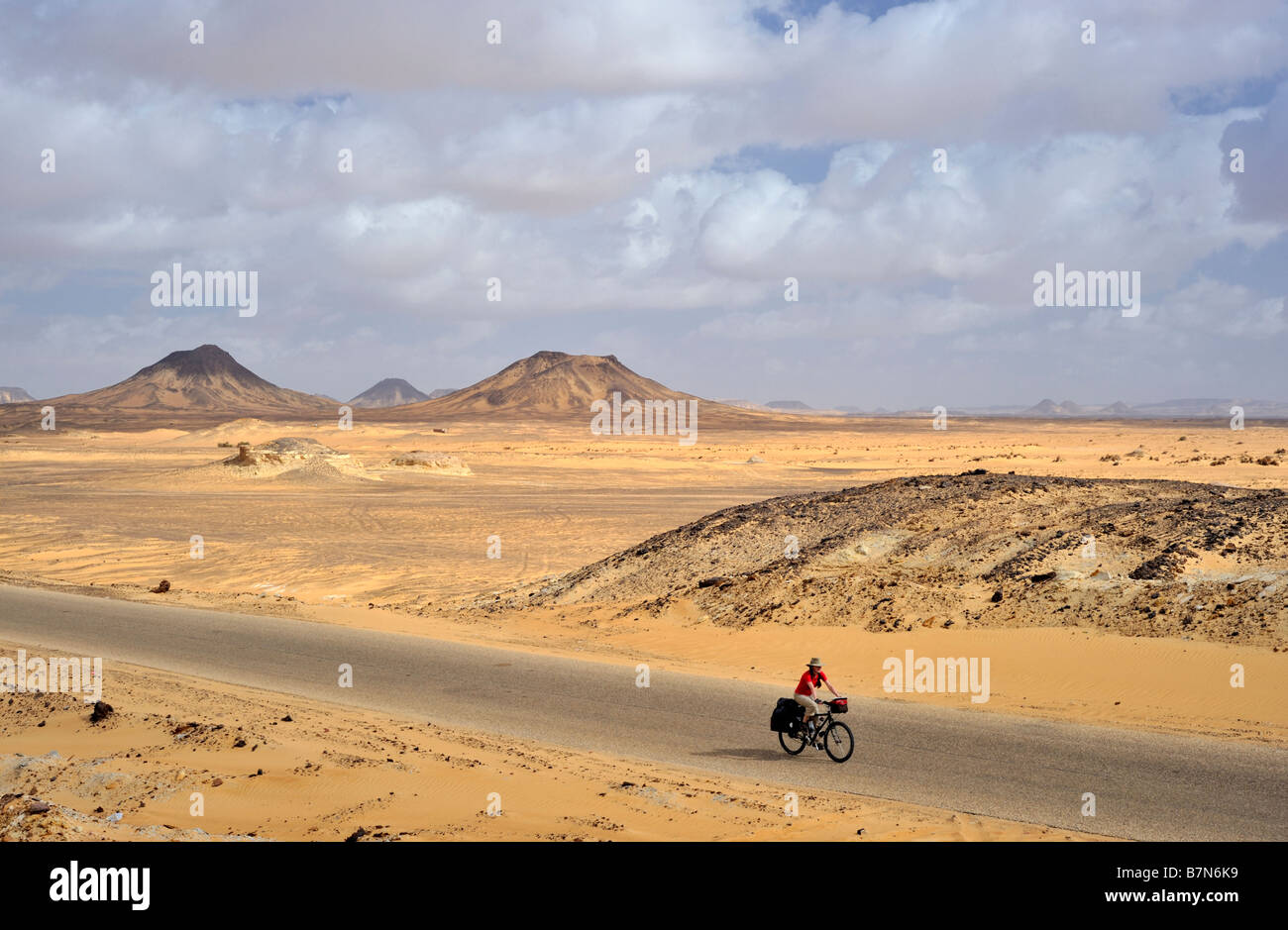 Femme touring cyclist dans de vastes paysages de désert occidental en Egypte Banque D'Images