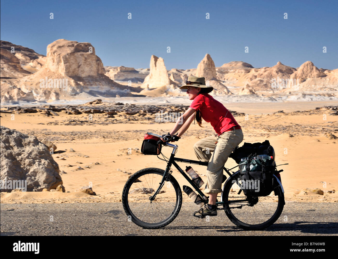 Western girl touring cyclist et location avec arrière-plan de collines inhabituelle dans le désert blanc de l'ouest de l'Egypte Banque D'Images