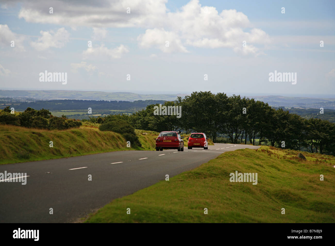 Le trafic sur une route à travers les landes du Parc National de Dartmoor au-dessus Horrabridge Devon England UK Banque D'Images