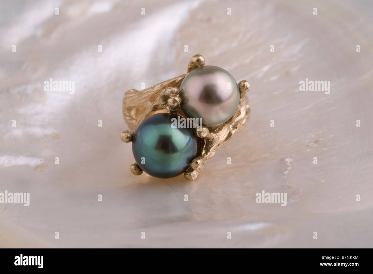 Bague perle, doublet - silver/white pearl, black pearl, dans l'or sur la nacre Banque D'Images
