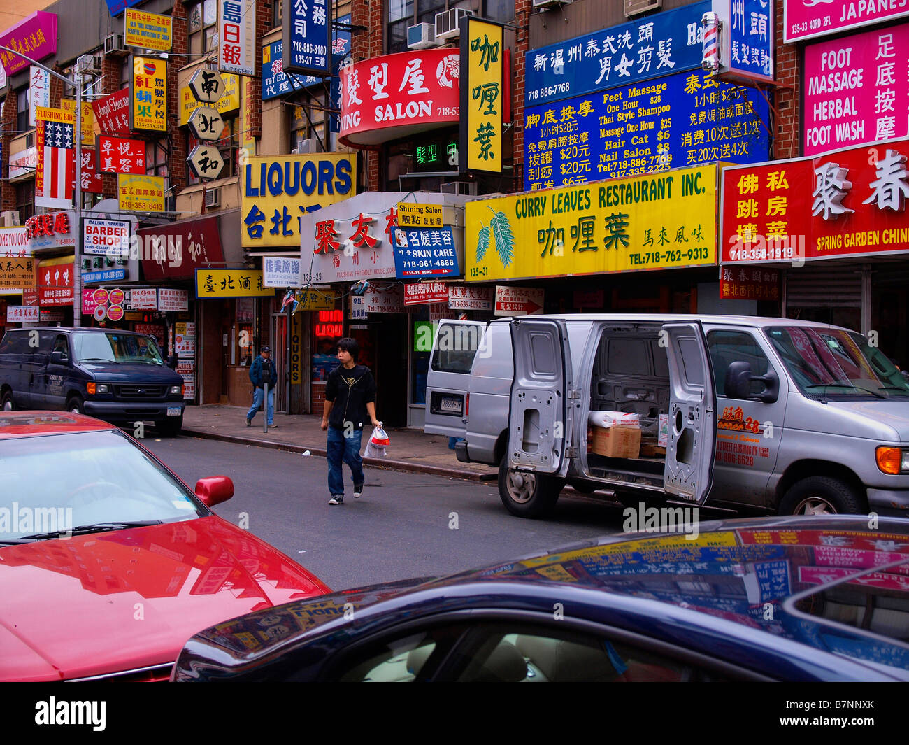 Une rue pleine de littéralement les petites entreprises publicité enseignes à l'intérieur dans le quartier chinois de Flushing, New York. Banque D'Images