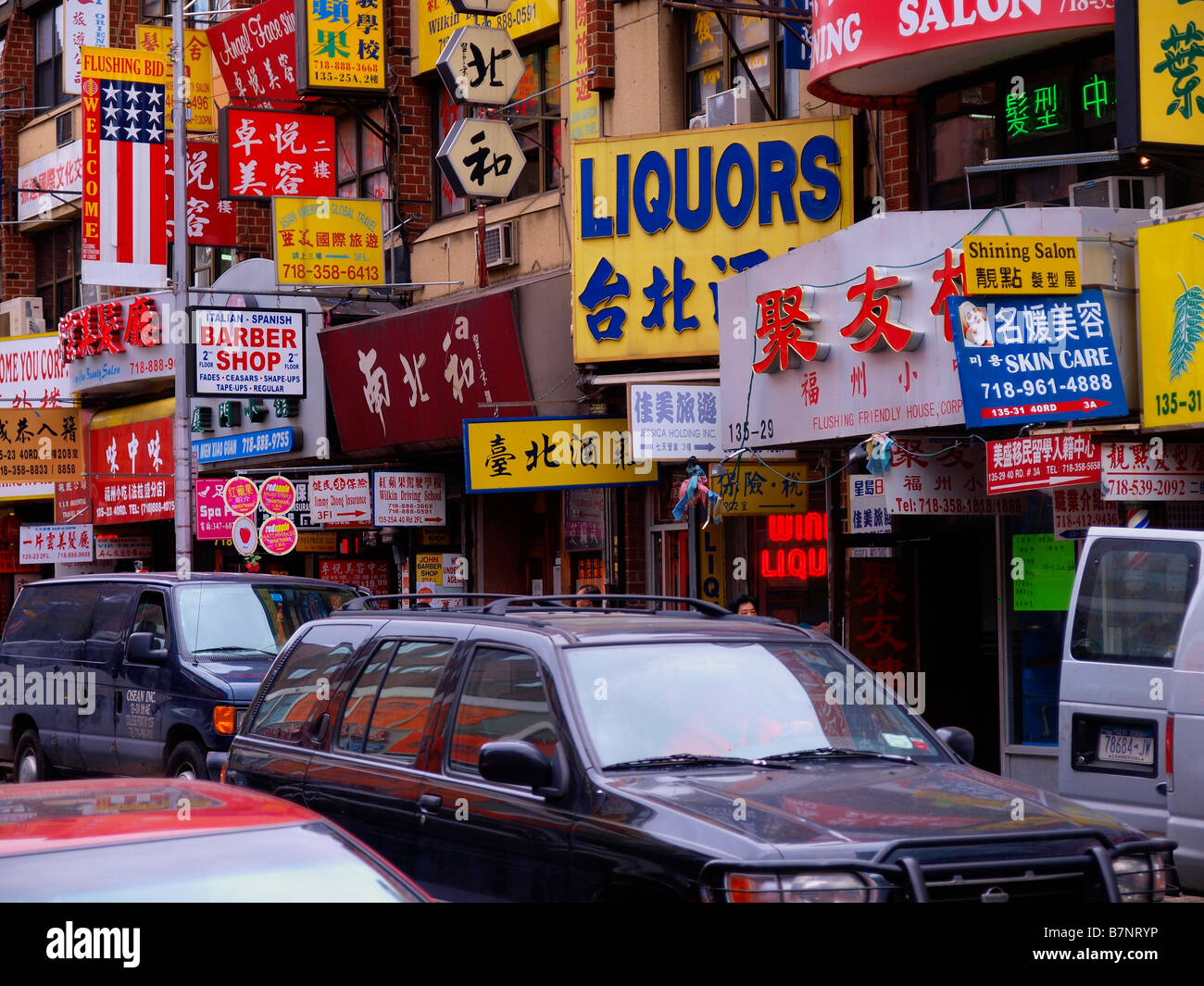 Une rue pleine de littéralement les petites entreprises publicité enseignes à l'intérieur dans le quartier chinois de Flushing, New York. Banque D'Images