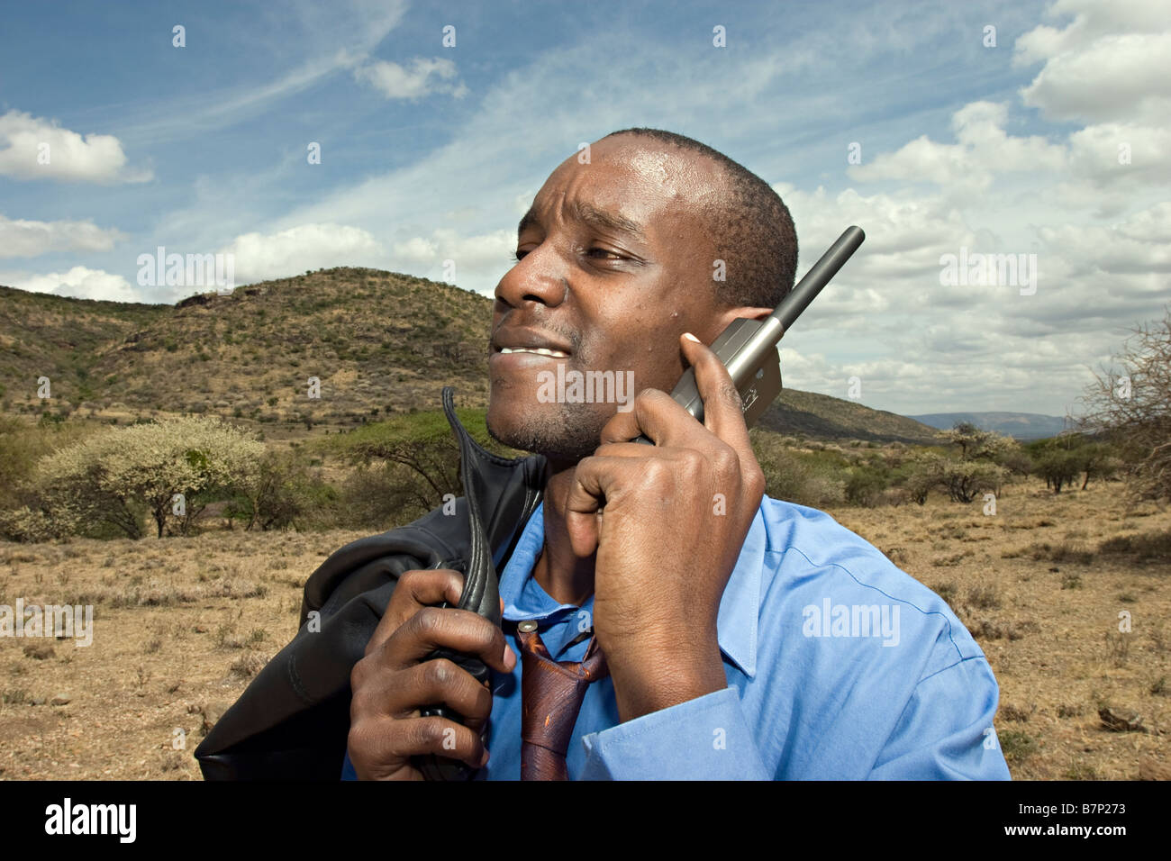 Un homme parlant sur son téléphone satellite dans la Communauté à l'extérieur. Masailand, au Kenya. Banque D'Images