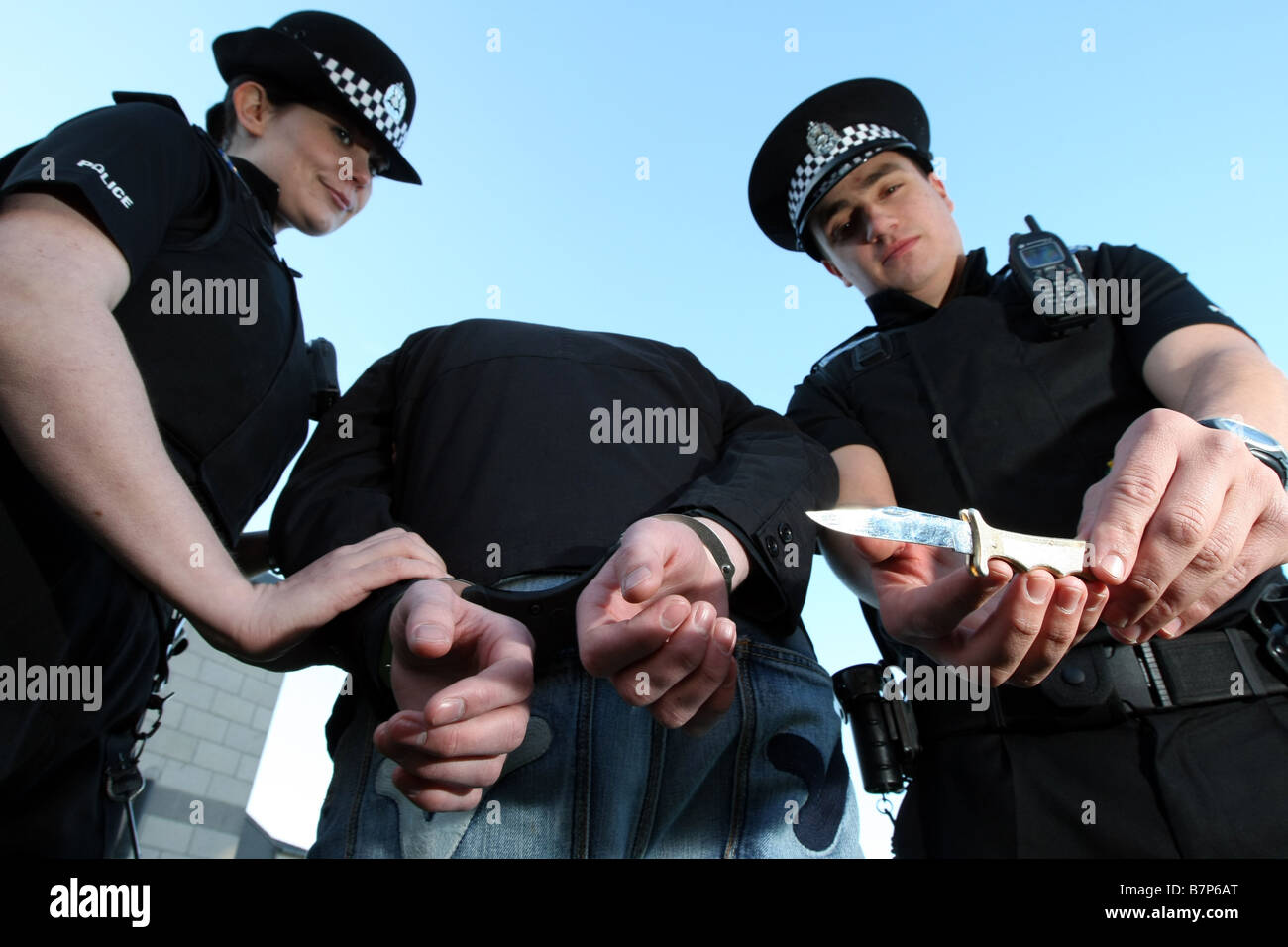 Des agents de police de Grampian Aberdeen, Écosse, Royaume-Uni, en train d'enlever une arme à lame d'un suspect dans les menottes Banque D'Images