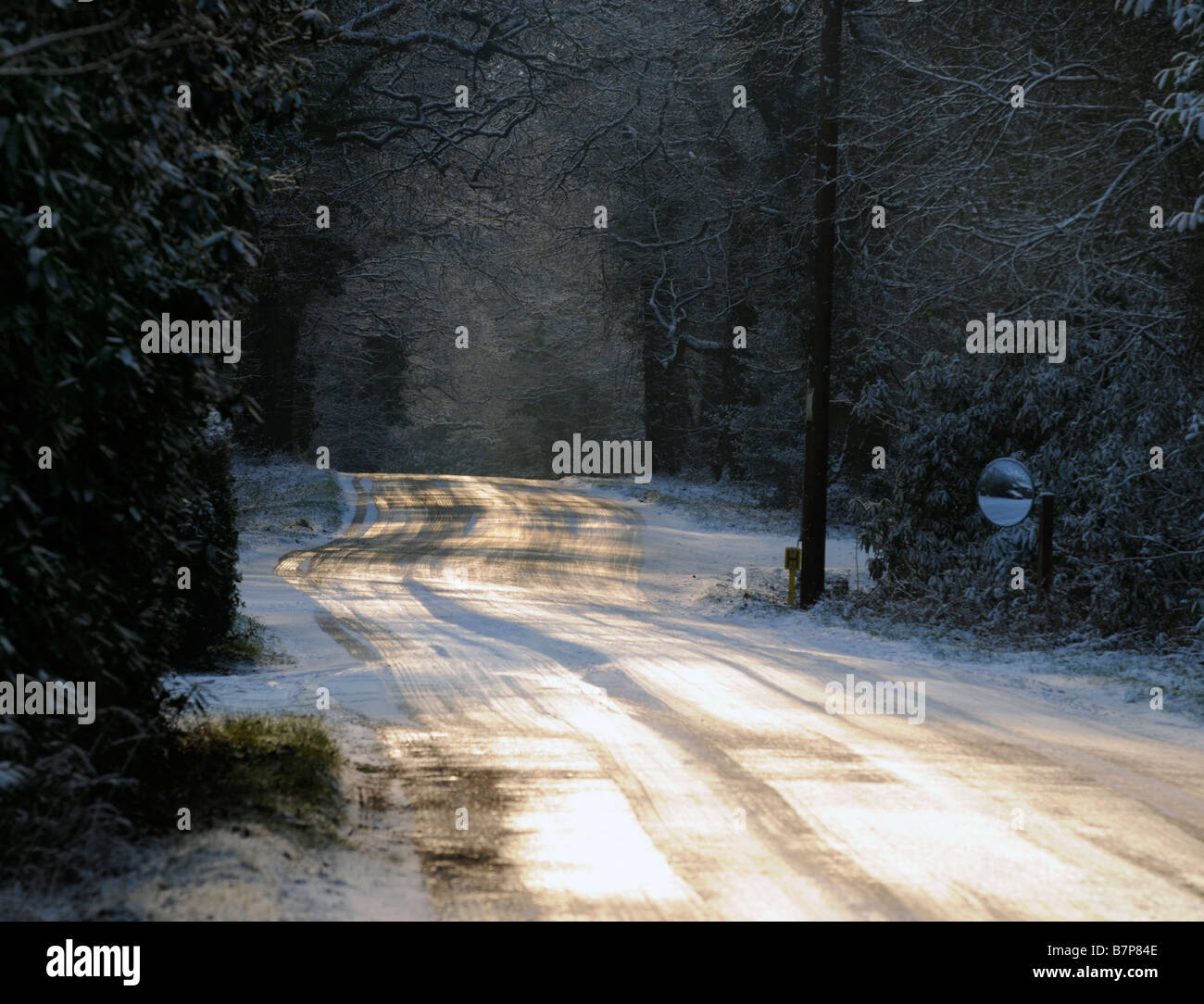 Soleil d'hiver étincelant off empty country road recouvert de glace Banque D'Images