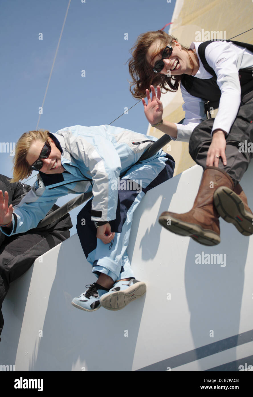 2 femmes marins age 20-25 s'amusant sur un voilier de course. Banque D'Images