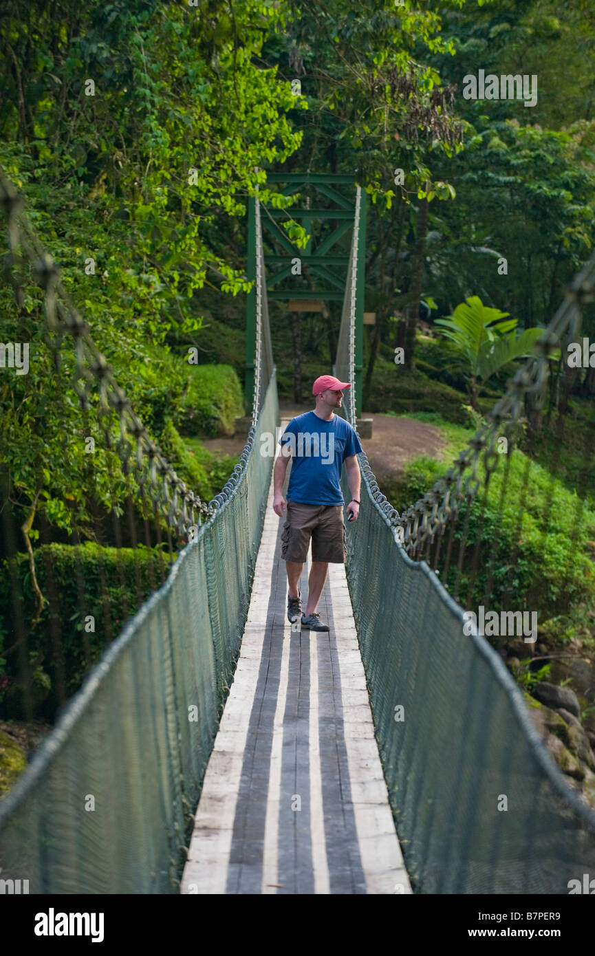 L'Amérique centrale, le Costa Rica. Un randonneur sur un pont suspendu sur la rivière Pacuare sauvage et magnifique. Banque D'Images