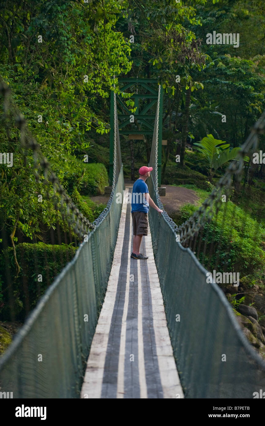 L'Amérique centrale, le Costa Rica. Un randonneur sur un pont suspendu sur la rivière Pacuare sauvage et magnifique. Banque D'Images