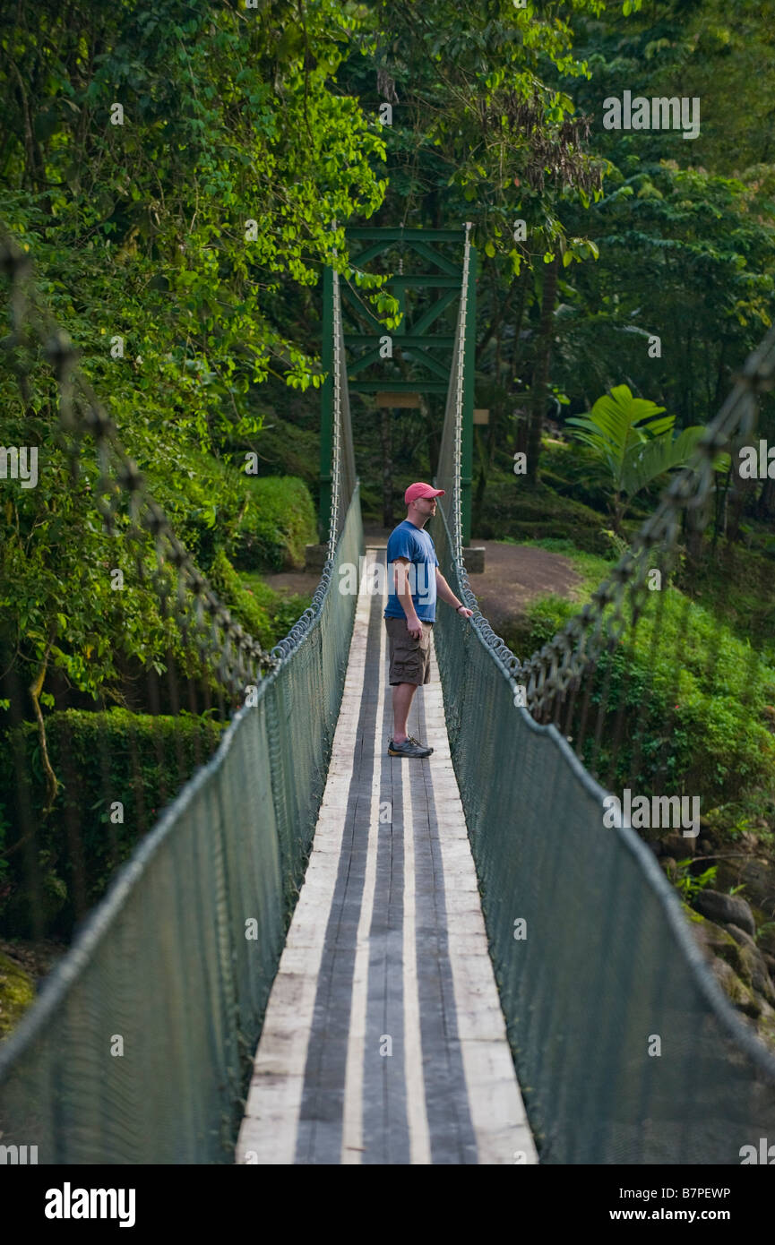 L'Amérique centrale, le Costa Rica. Un randonneur sur un pont suspendu sur la rivière Pacuare sauvage et magnifique. Banque D'Images