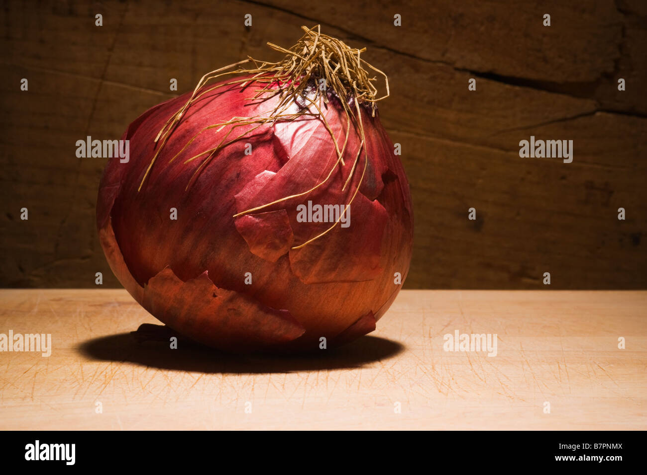 Studio les natures mortes d'un oignon rouge en face d'un fond en bois Banque D'Images