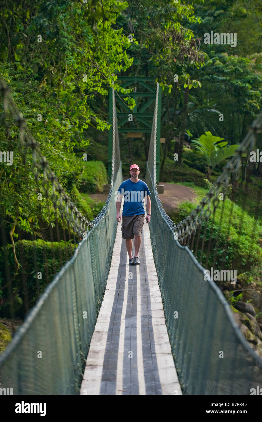 L'Amérique centrale, le Costa Rica. Un randonneur sur un pont suspendu sur la rivière Pacuare sauvage et magnifique. Banque D'Images