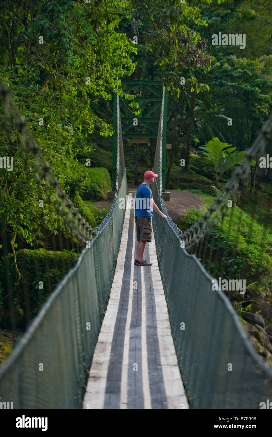 L'Amérique centrale, le Costa Rica. Un randonneur sur un pont suspendu sur la rivière Pacuare sauvage et magnifique. Banque D'Images