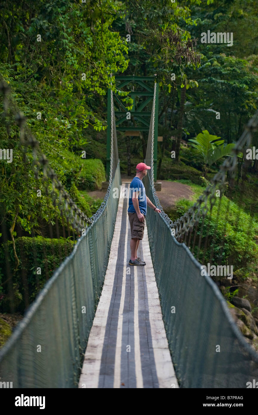 L'Amérique centrale, le Costa Rica. Un randonneur sur un pont suspendu sur la rivière Pacuare sauvage et magnifique. Banque D'Images