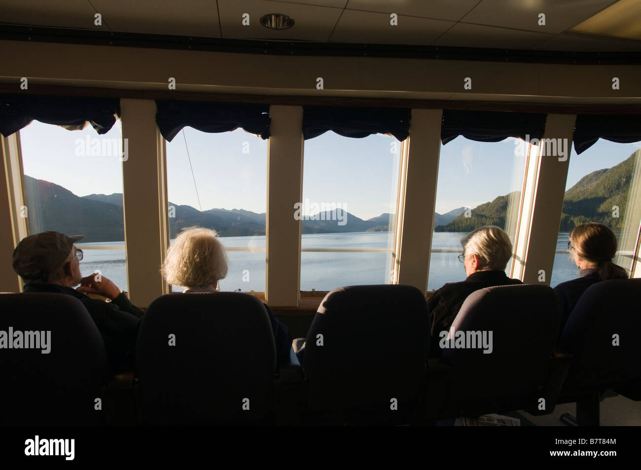 Les touristes à la recherche par la fenêtre de la plate-forme d'observation de l'Alaska Marine Highway le long du Passage intérieur sud-est de l'Alaska Banque D'Images