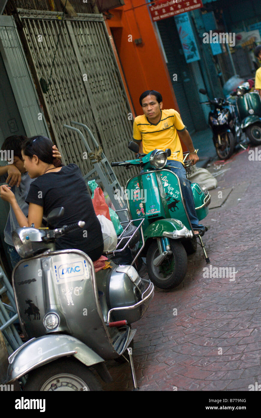 Les jeunes à la mode Thai s traîner avec les scooters Vespa classique populaire dans le centre de Chinatown Bangkok Thaïlande Banque D'Images