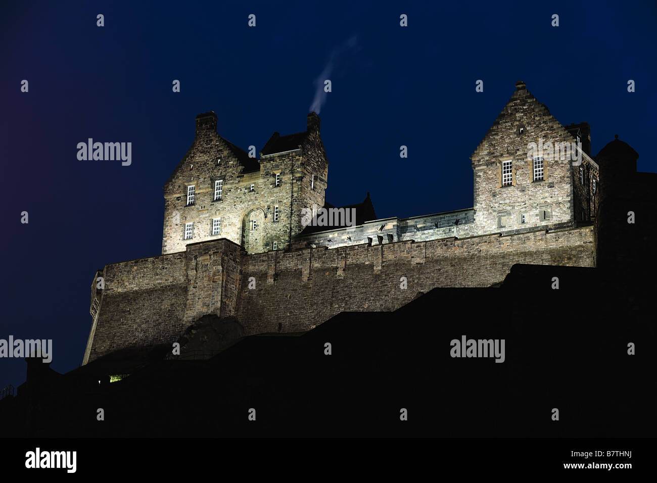 Le Château d'Édimbourg, en Écosse, de l'Ouest, allumé à la tombée de la nuit. Banque D'Images