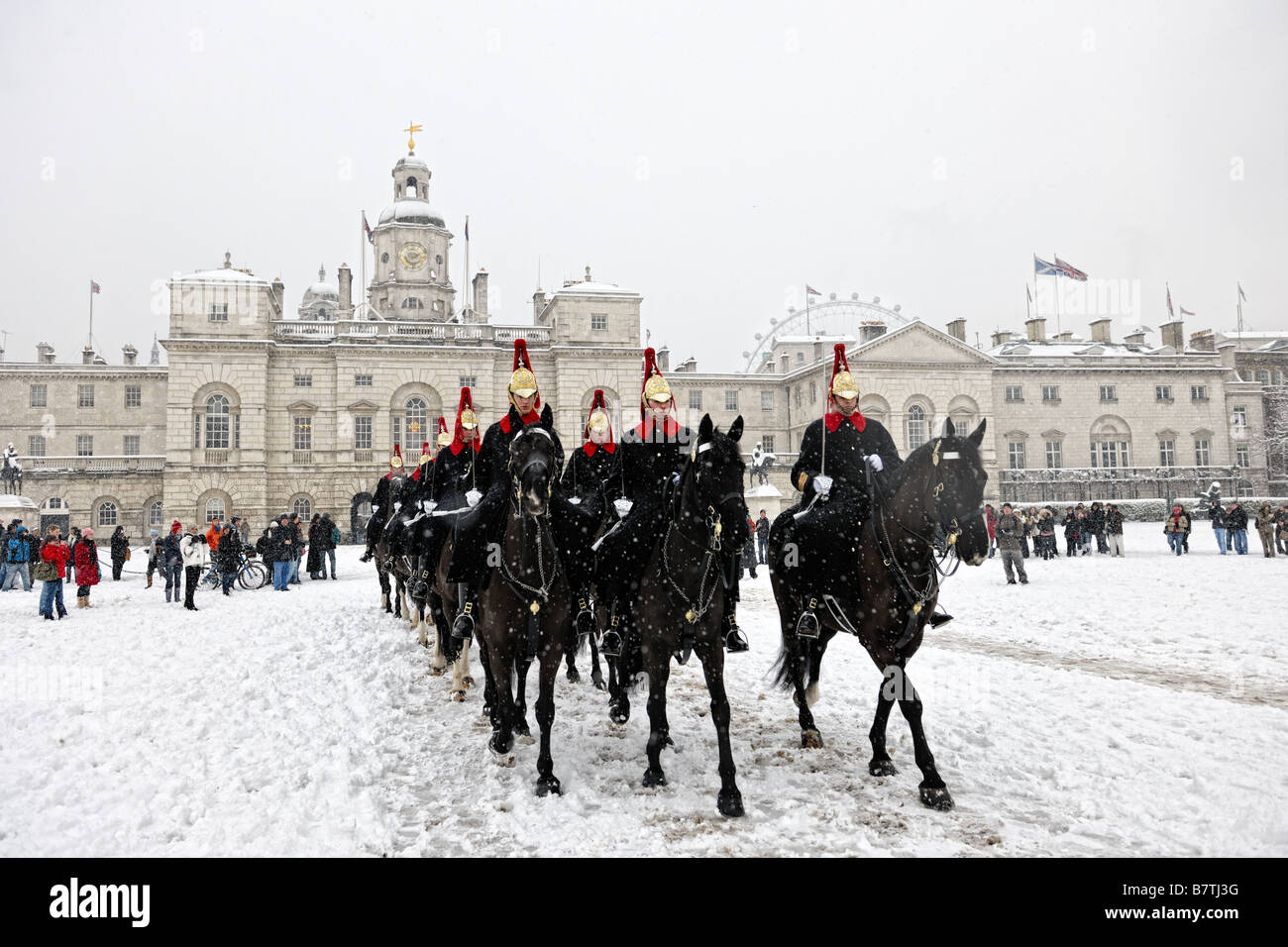 La cavalerie de famille équitation à travers la neige à travers Horseguards Parade pour fonctions au palais de Buckingham après un changement de garde côtière canadienne Banque D'Images