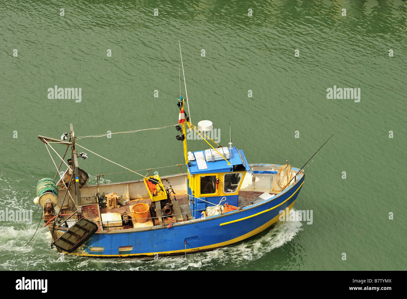 Un petit bateau de pêche de retourner à Harbour Banque D'Images