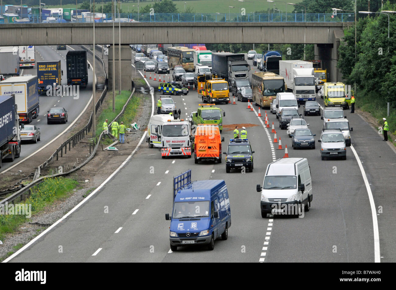 Vue aérienne M25 file d'attente sur autoroute de la circulation retardée de camions routiers lents qui passent l'accident de la route avec des véhicules de police et de récupération Angleterre Royaume-Uni Banque D'Images