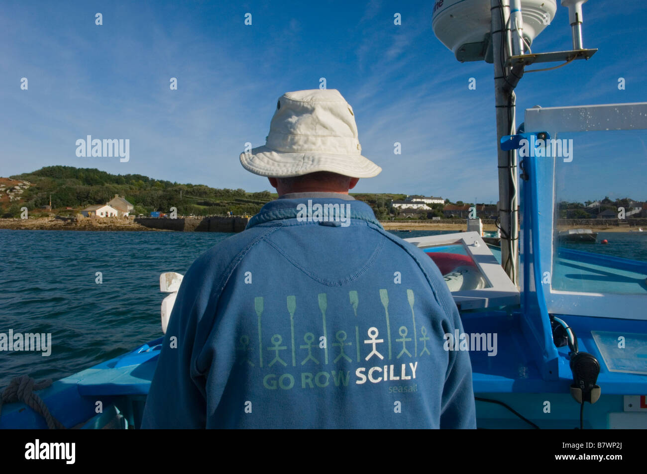 Taxi ferry inter-îles avec le patron portait un chapeau de soleil et un chandail avec le slogan : "Rendez-vous des rangs Scilly Isles of Scilly, Angleterre, RU Banque D'Images