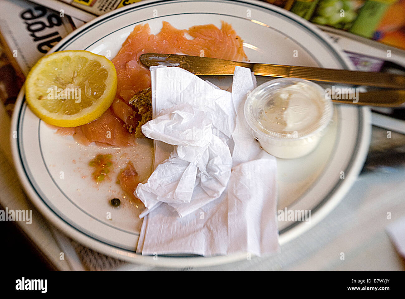 Une plaque de Chine blanc utilisé lox, Bagels et fromage à la crème, avec un couteau, serviette, et de citron Banque D'Images