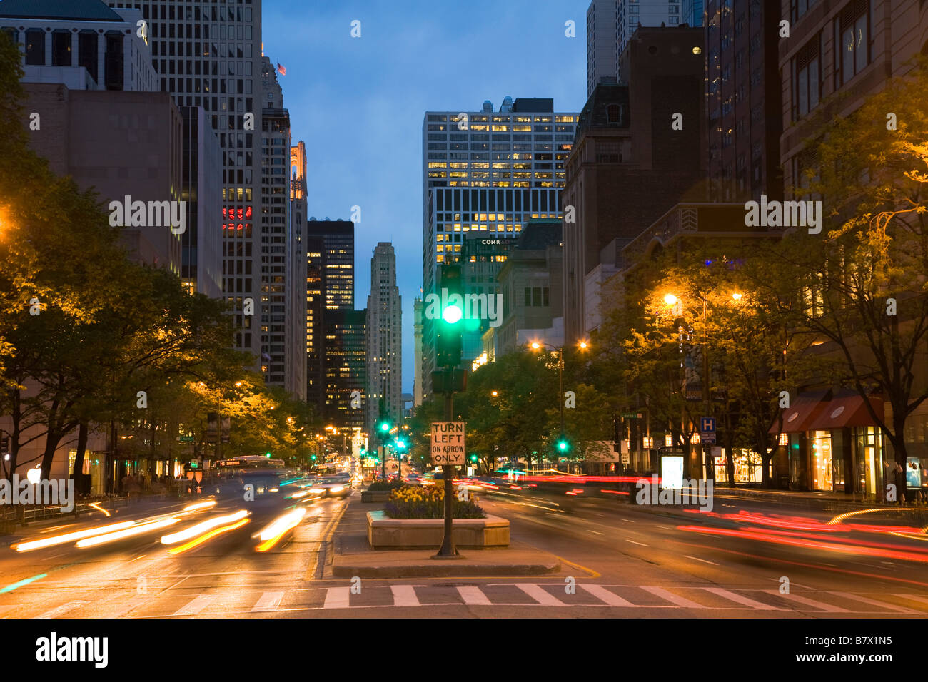 L'ILLINOIS Chicago Traffic signal en médiane de Michigan Avenue au crépuscule flou de voitures qui passent à gauche sur panneau de flèche Banque D'Images