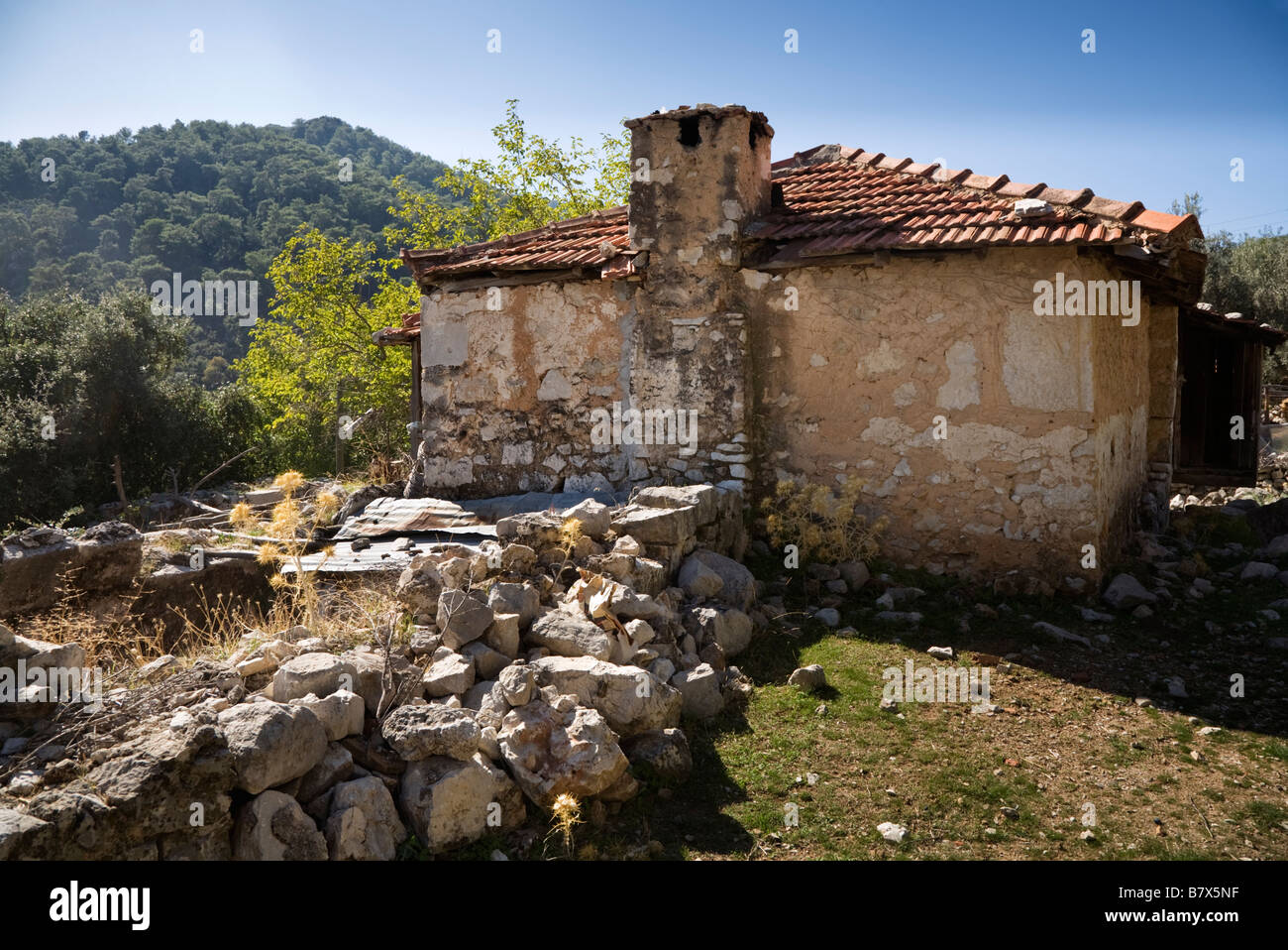 Une vue arrière d'une maison construite en pierre turc avec un toit en tuiles de terre cuite en villageTurkey Sidyma Banque D'Images