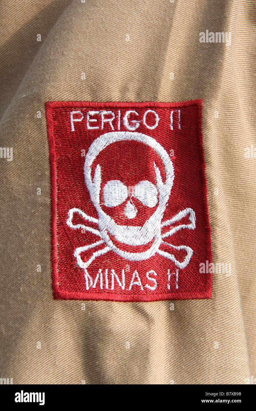 Tête de mort et de "danger mines en portugais d'avertissement sur un manchon avertir patch par les démineurs au Mozambique. Banque D'Images