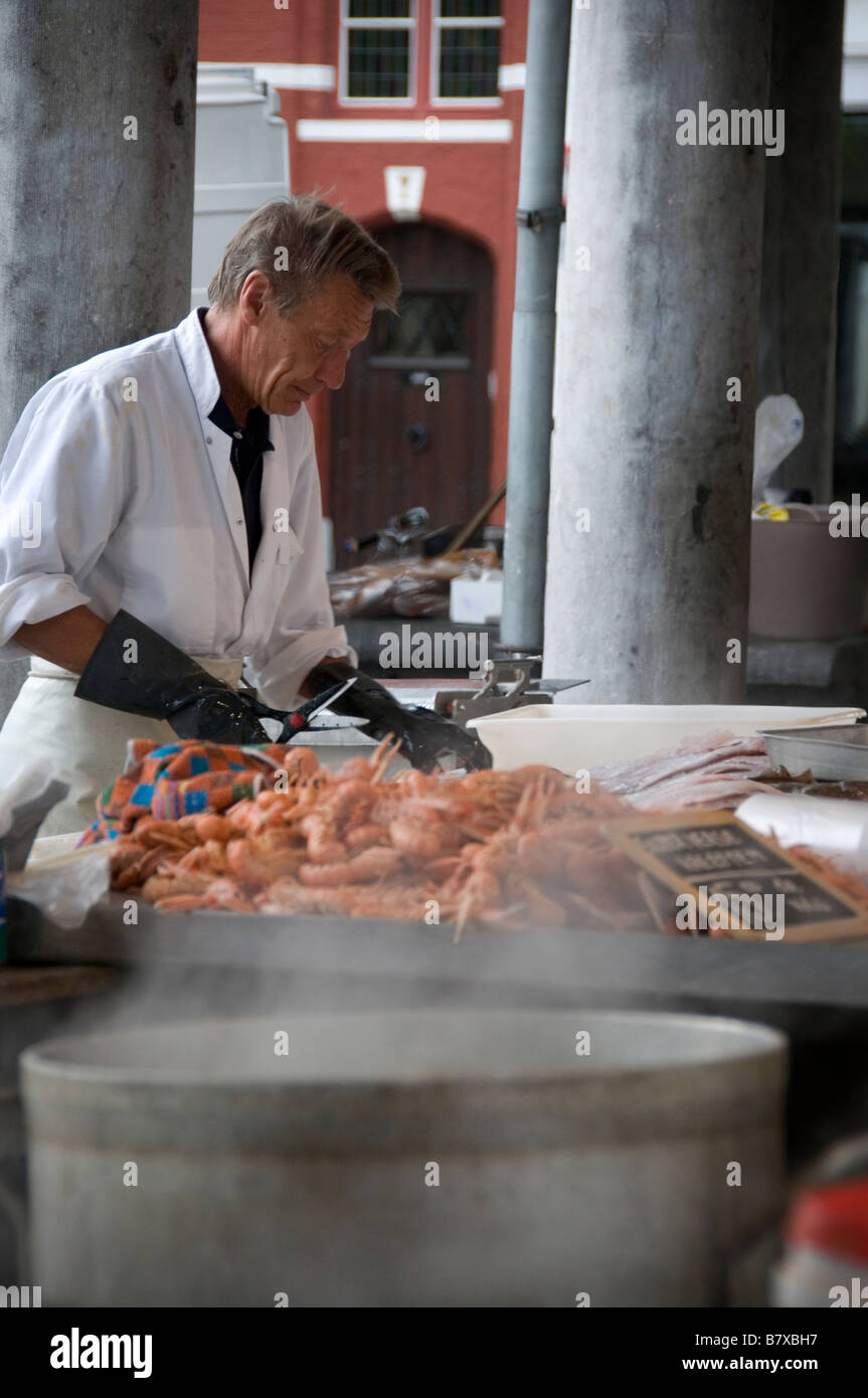 Poissonnier prépare les poissons produisent au marché aux poissons de Bruges Brugge Flandre occidentale Belgique Banque D'Images