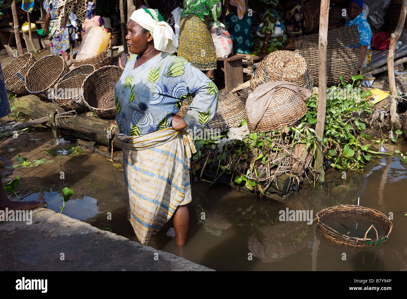Femme de la région s'étend sur son dos tandis que debout dans la rivière pour attraper des poissons à un marché de poissons Banque D'Images