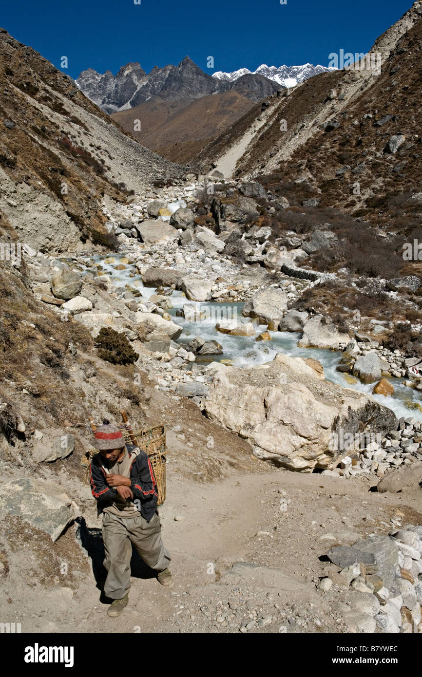 Porter népalais transportant des marchandises à Dingboche environs en parc national de Sagarmatha Vallée de l'Everest région de Khumbu au Népal Banque D'Images