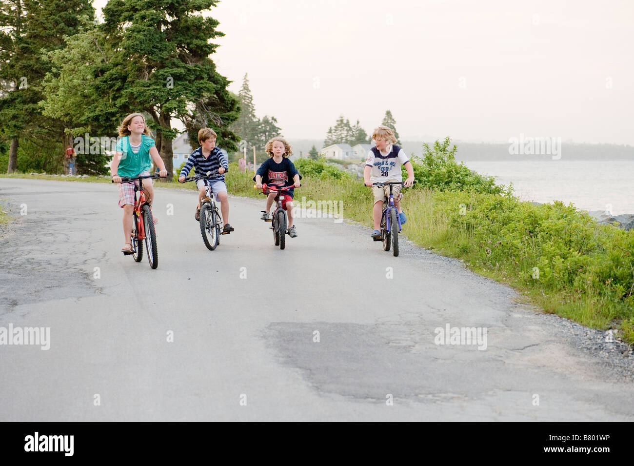 Les enfants équitation leurs vélos ensemble. Banque D'Images