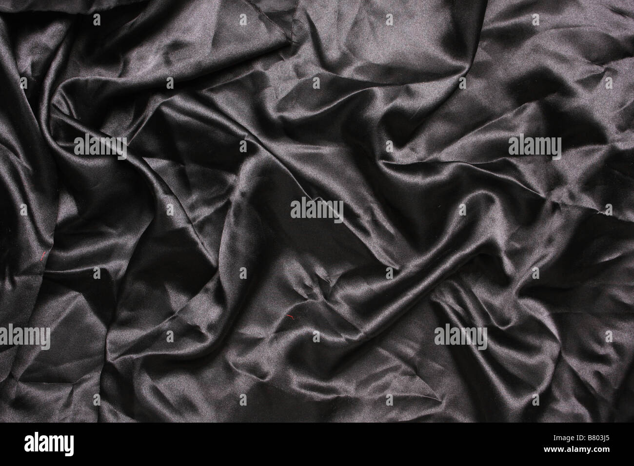 En satin de couleur noire en plongée des plis et replis de la création de toutes sortes de formes et ombres Banque D'Images