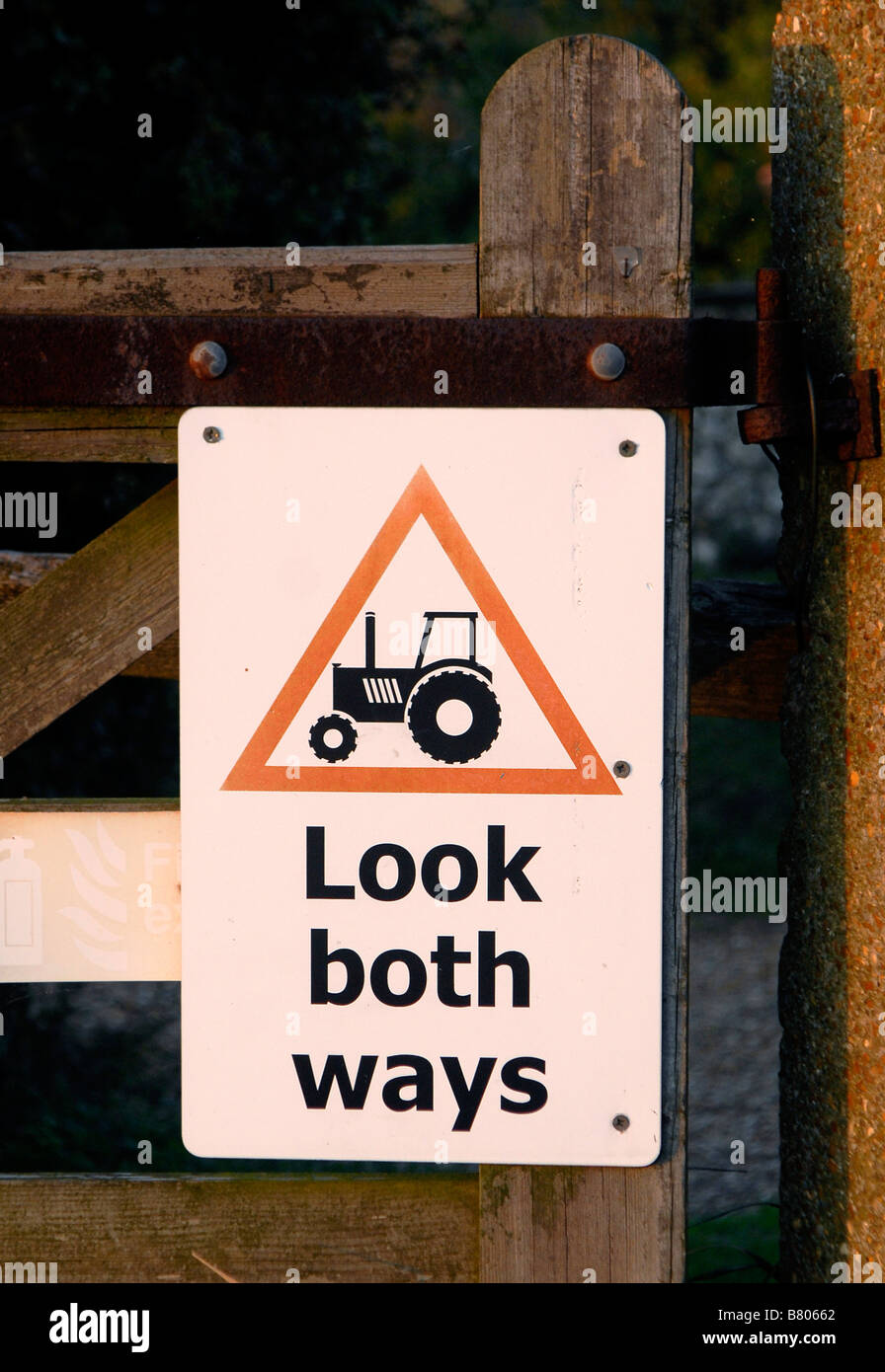 Un signe avise les personnes de faire attention de tracteurs dans une ferme Banque D'Images