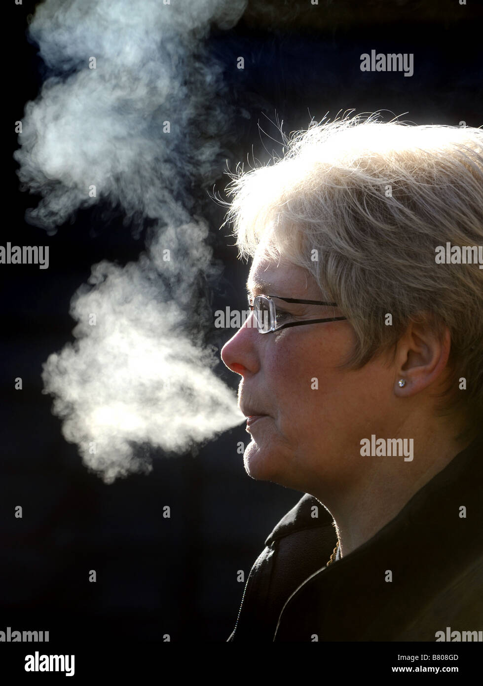 Libre de fumée de cigarette de sa bouche Banque D'Images