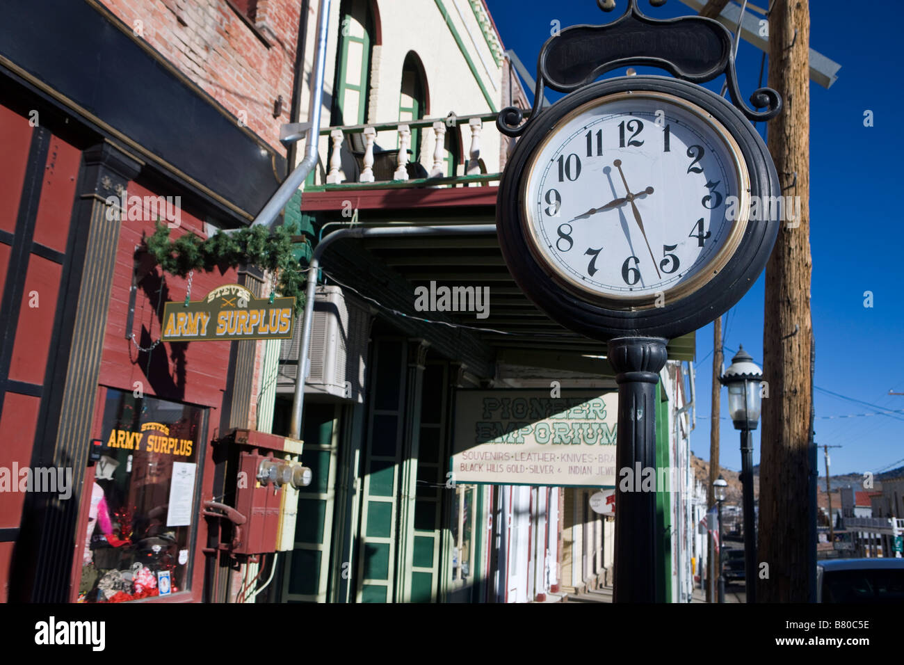 Boutiques avec pendaison signe un réveil et un trottoir de bois à pied côté rue principale ligne de Virginia City dans le Nevada Banque D'Images