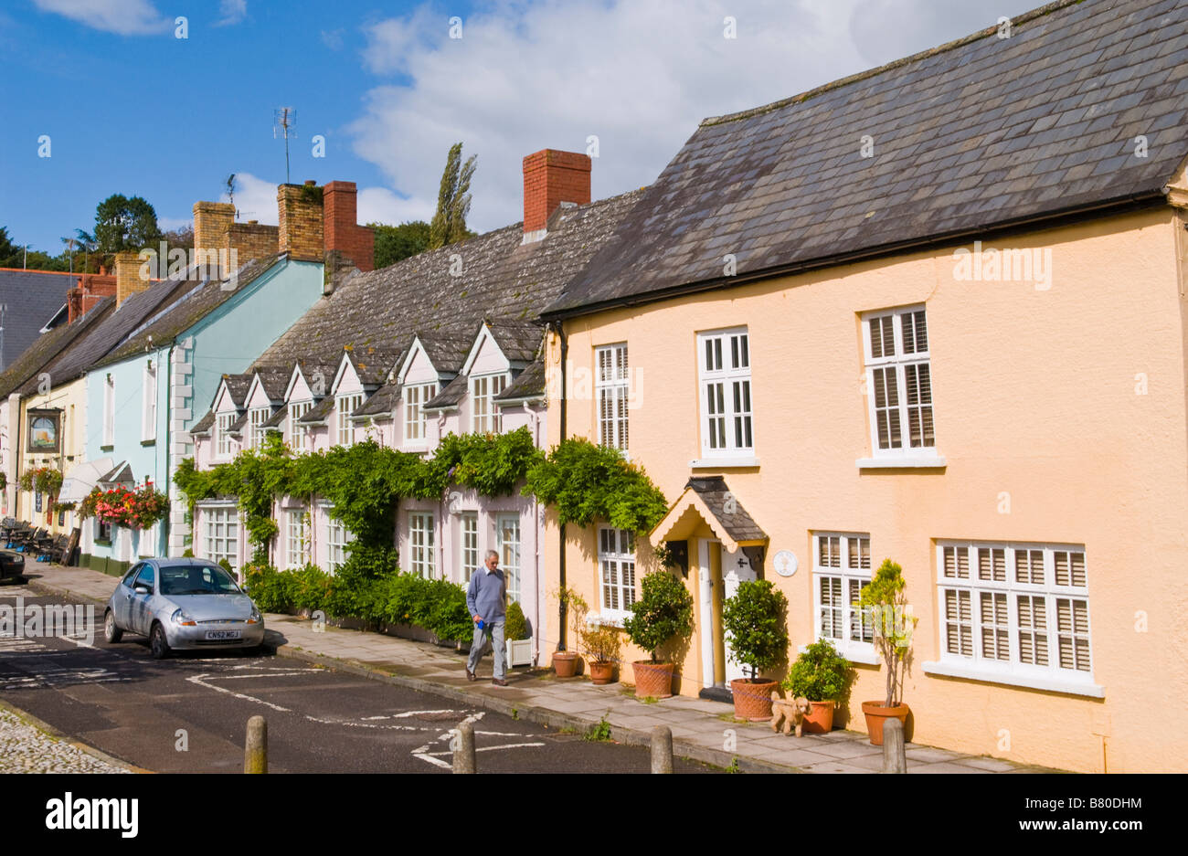 Logement ville rurale typique aux beaux jours avec l'homme chien marche sur le plomb Usk Monmouthshire South Wales UK Banque D'Images