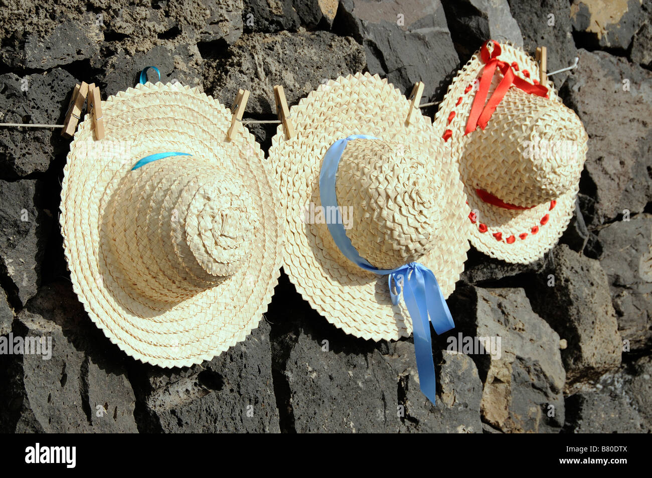 Les chapeaux de paille à la main dans les îles Canaries liée sur une ligne  et en vente comme souvenirs pour les touristes Photo Stock - Alamy