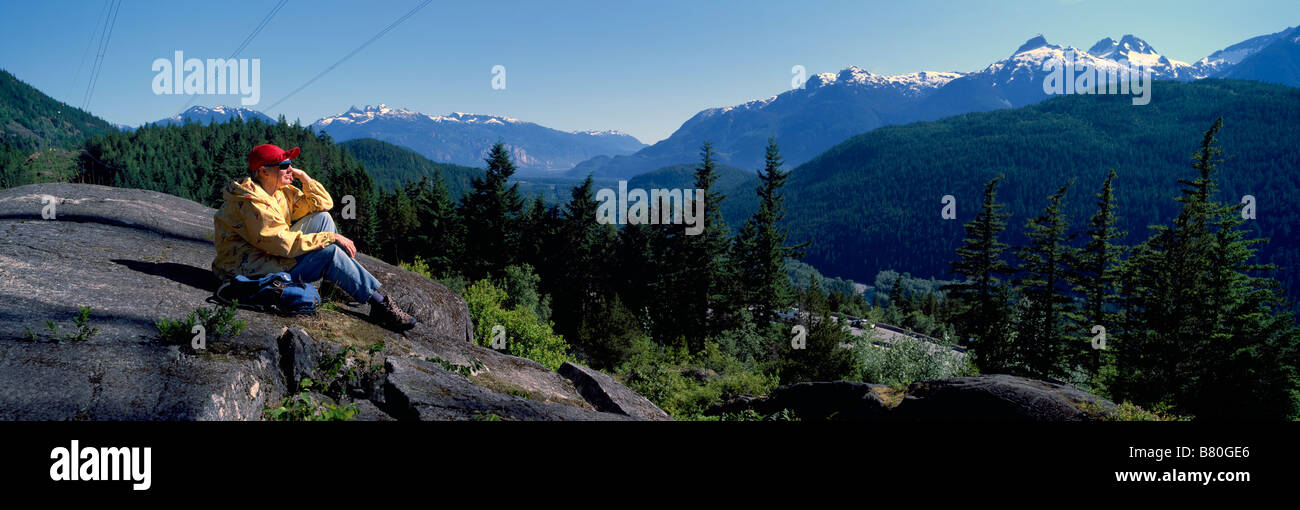 Un Female Hiker en contemplant la vue sur les montagnes de Tantalus près de Whistler et de Squamish, British Columbia Canada Banque D'Images