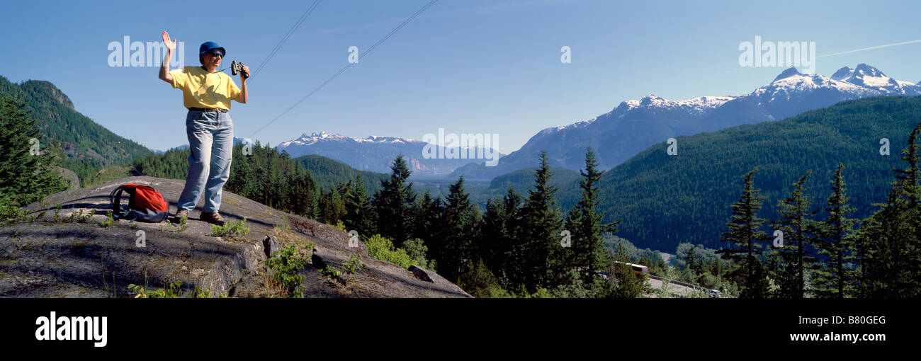 Un Female Hiker forme et profiter de la vue de la chaîne de montagnes de Tantalus près de Whistler et de Squamish, British Columbia Canada Banque D'Images