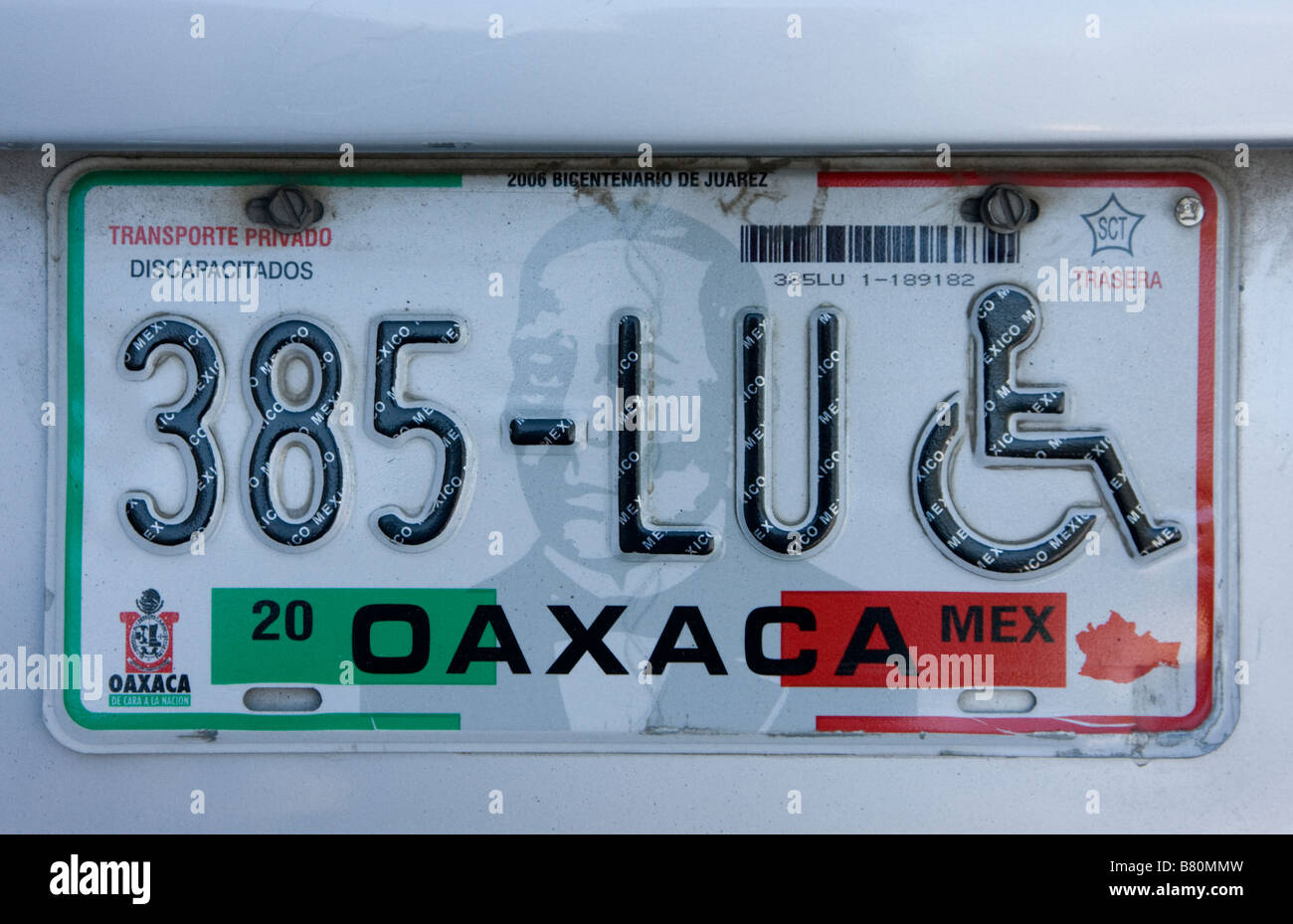 Oaxaca, Mexique. La plaque d'immatriculation automobile privé, Etat de Oaxaca, montrant emblème pour handicapés ou personnes à mobilité réduite Parking Privilège. Image Benito Juarez. Banque D'Images
