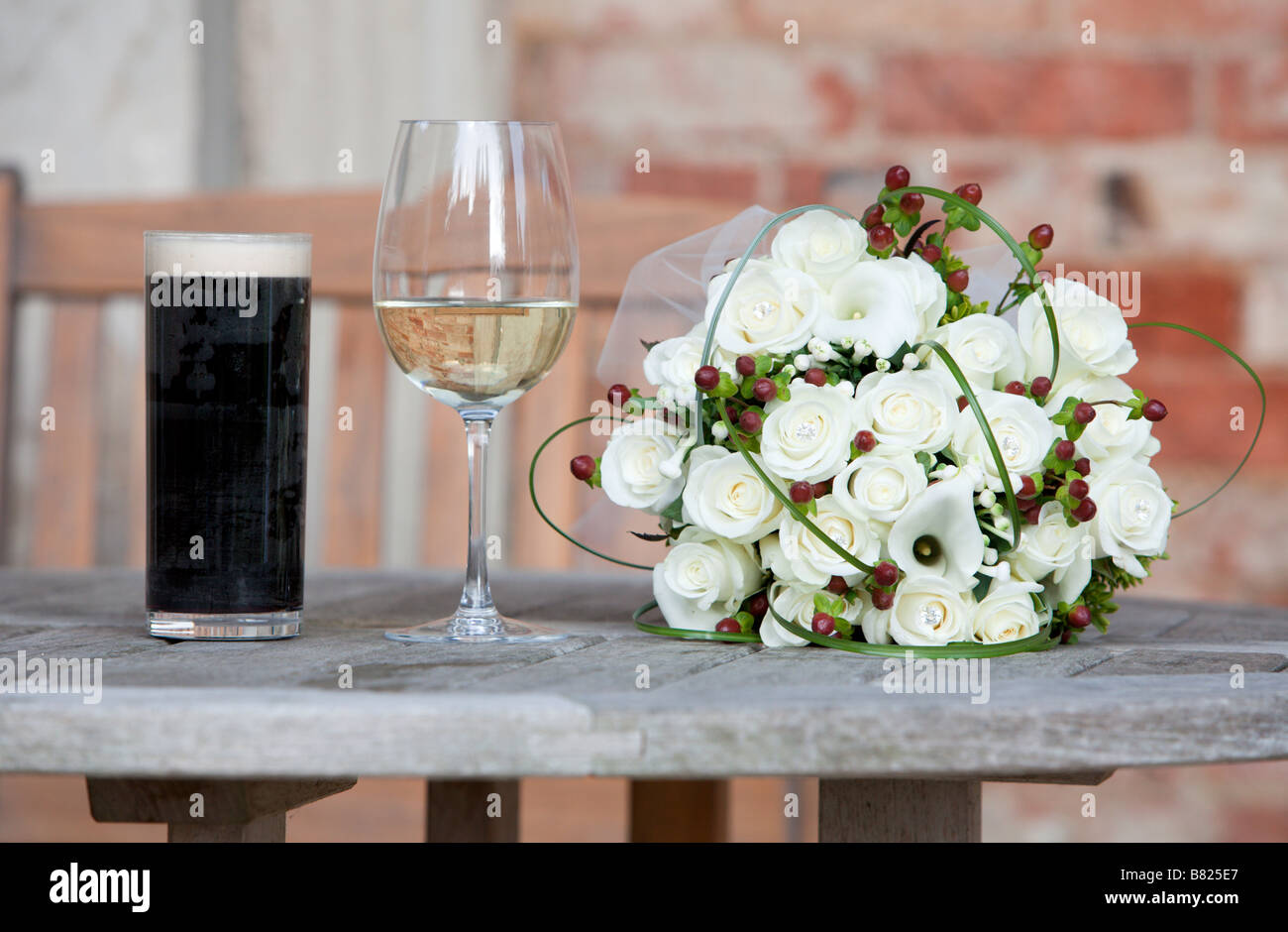 Des fleurs de mariage à côté d'un glasss de vin et un verre de bière Banque D'Images